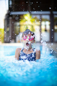 girl playing in the pool with goggles
